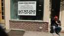 Seorang warga berada di depan sebuah toko yang tutup di West Village, New York (12/4). Menurut Badan Real Estate New York (REBNY), jumlah toko tutup di New York terus meningkat. (Spencer Platt / Getty Images / AFP)