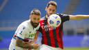 Pemain AC Milan, Hakan Calhanoglu, berebut bola dengan pemain Sampdoria, Lorenzo Tonelli, pada laga Liga Italia di Stadion San Siro, Minggu (4/4/2021). Kedua tim bermain imbang 1-1. (AP Photo/Antonio Calanni)