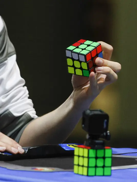 Peserta menyelesaikan kubus Rubik saat mengikuti kejuaraan kubus Rubik Dunia di Saint Denis, Paris, Prancis (16/7). Rubik sendiri adalah sebuah permainan yang mengasah kemampuan konsentrasi. (AFP Photo/Geoffroy Van Der Hasselt)