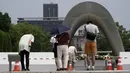 Warga menaruh hormat di depan cenotaph untuk para korban bom atom di Hiroshima, Jepang, Senin (3/8/2020). Jepang akan memperingati 75 tahun bom atom di Hiroshima pada 6 Agustus 2020. (AP Photo/Eugene Hoshiko)FOTO: Jepang Bersiap Memperingati 75 Tahun Bom Hiroshima