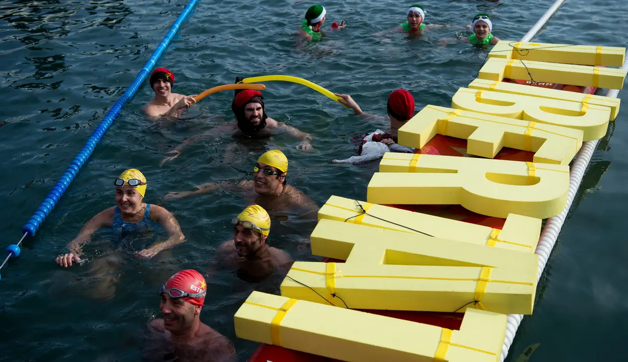 Para peserta ambil bagian dalam kompetisi renang Copa Nadal edisi ke-109 di Port Vell Barcelona, Selasa (25/12). Lomba tradisional ini sudah menjadi tradisi lama yang mereka lakukan tiap tahun pada hari natal. (Josep LAGO / AFP)