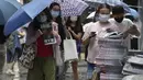 Orang-orang membeli edisi terakhir Apple Daily di stan surat kabar di jalan pusat kota di Hong Kong, Kamis (24/6/2021). Sebelumnya, kantor surat kabar itu igerebek polisi dan pemilik beserta lima eksekutifnya ditangkap di bawah undang-undang keamanan nasional yang baru. (AP Photo/Vincent Yu)