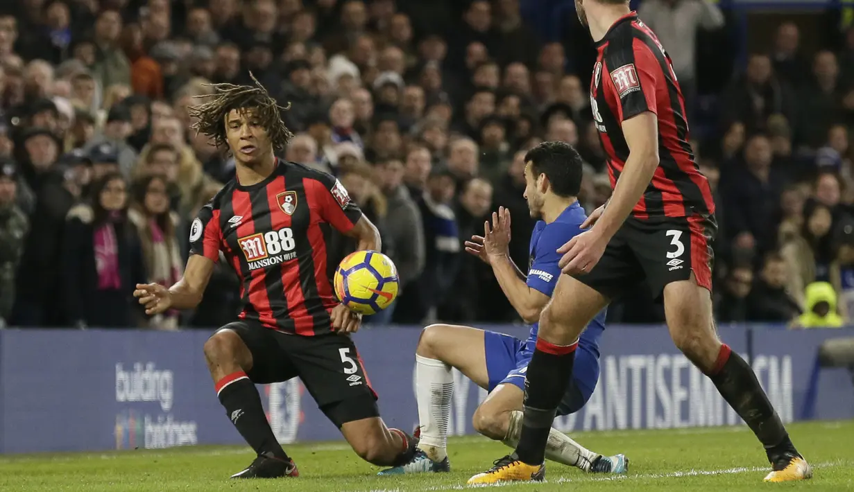 Aksi pemain Bournemouth, Nathan Ake (kiri) menghalau bola sepakan Pedro pada lanjutan Premier League di Stamford Bridge, London, (31/1/2018). Chelsea kalah 0-3. (AP/Tim Ireland)