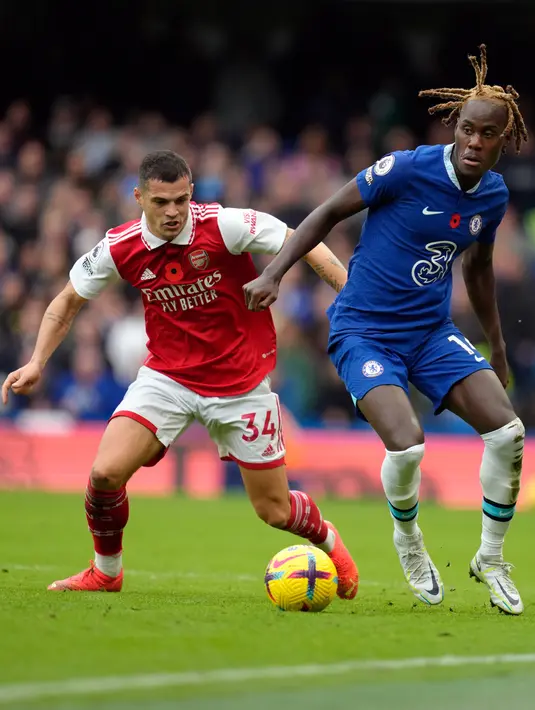 Pemain Chelsea Trevoh Chalobah (kanan) berebut bola dengan pemain Arsenal Granit Xhaka pada pertandingan sepak bola Liga Inggris di Stadion Stamford Bridge, London, Inggris, 6 November 2022. Arsenal kembali memuncaki klasemen Liga Inggris usai mengalahkan Chelsea dengan skor 1-0. (AP Photo/Kirsty Wigglesworth)