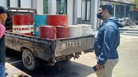 Polisi mengamankan barang bukti berupa kendaraan pick up L300 bernopol S8142 UB dan 12 drum berisi solar. (Liputan6.com/ Ahmad Adirin)