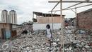 Seorang bocah melintas di dekat puing-puing di Kampung Akuarium, Penjaringan, Jakarta Utara, Senin (30/1). Saat ini ratusan warga masih tinggal di lokasi yang telah digusur oleh Pemprov DKI. (Liputan6.com/Gempur M Surya)