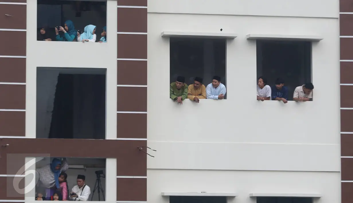 Warga menyaksikan prosesi pemakaman jenazah tokoh PBNU KH Hasyim Muzadi di Pondok Pesantren Al Hikam, Beji, Depok, Kamis (16/3). KH Hasyim Muzadi meninggal dunia  setelah mengalami sakit beberapa waktu lalu. (Liputan6.com/Immanuel Antonius)