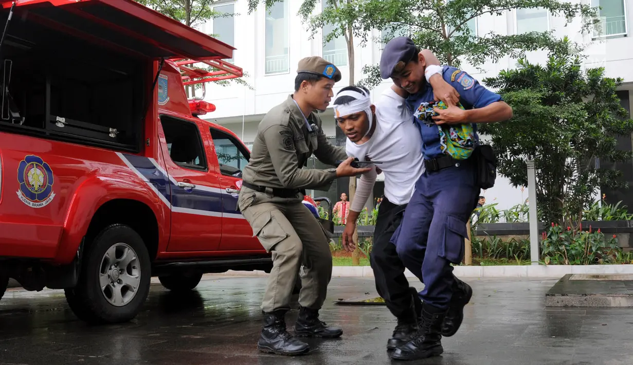 Petugas penyelamat membantu korban luka saat simulasi penanggulangan kebakaran dan gempa bumi di Balai Kota Tangerang Selatan, Banten, Kamis (26/4). Acara ini diikuti oleh berbagai komponen pemerintah, swasta, dan masyarakat. (Merdeka.com/Arie Basuki)