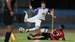 Gelandang Amerika Serikat, Christian Pulisic, terjatuh saat dilanggar pemain Trinidad Tobago pada laga kualifikasi Piala Dunia di Stadion Ato Boldon, Selasa (10/10/2017). Trinidad dan Tobago menang 2-1 atas  Amerika Serikat. (AP/Rebecca Blackwell)