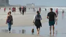 Warga berjalan di pantai selama pandemi Covid-19 di Jacksonville Beach, Florida (17/4/2020). Gubernur Ron DeSantis memberikan lampu hijau beberapa pantai dan taman untuk dibuka kembali jika dapat dilakukan dengan aman setelah ditutup karena Covid-19.  (Will Dickey/The Florida Times-Union via AP)