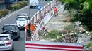 Pekerja menebang pohon untuk menyelesaikan proyek kereta api ringan atau Light Rail Transit (LRT) di kawasan Kuningan, Jakarta, Rabu (26/7). Penebangan dilakukan untuk pembangunan proyek LRT Cawang-Dukuh Atas sepanjang 10,5 km. (Liputan6.com/Helmi Afandi)