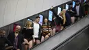 Orang-orang menggunakan eskalator saat ambil bagian dalam 'No Trousers On The Tube Day' atau No Pants Subway Ride di London Underground,  pusat Kota London, Minggu (12/1/2020). New York menjadi kota pertama yang menghajat acara naik kereta tanpa celana ini sejak tahun 2002. (DANIEL LEAL-OLIVAS/AFP)