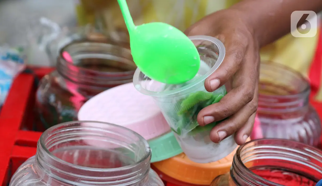 Pedagang meracik minuman untuk berbuka puasa di kawasan Bendungan Hilir, Jakarta, Sabtu (25/4/2020). Meski ditengah pandemi virus Covid-19, masyarakat masih antusias berburu penganan berbuka puasa dengan tetap menerapkan pola jaga jarak dan memakai masker. (Liputan6.com/Helmi Fithriansyah)