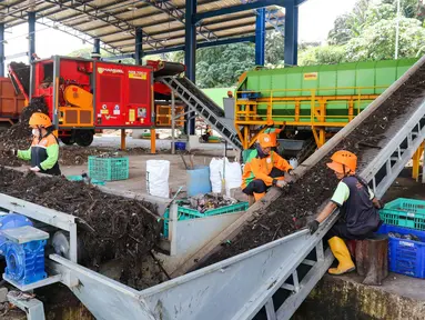 Pekerja melakukan pemilahan sampah dari mesin pencacah yang akan dijadikan pupuk kompos di tempat penyaringan sampah di TB Simatupang, Jakarta, Selasa (9/1/2024). (Liputan6.com/Herman Zakharia)