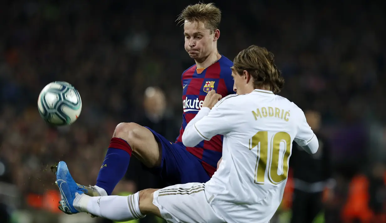 Gelandang Real Madrid, Luka Modric berebut bola dengan gelandang Barcelona, Frenkie de Jong pada pertandingan lanjutan La Liga Spanyol di stadion Camp Nou (18/12/2019). Barcelona bermain imbang 0-0 atas Real Madrid. (AP Photo/Joan Monfort)