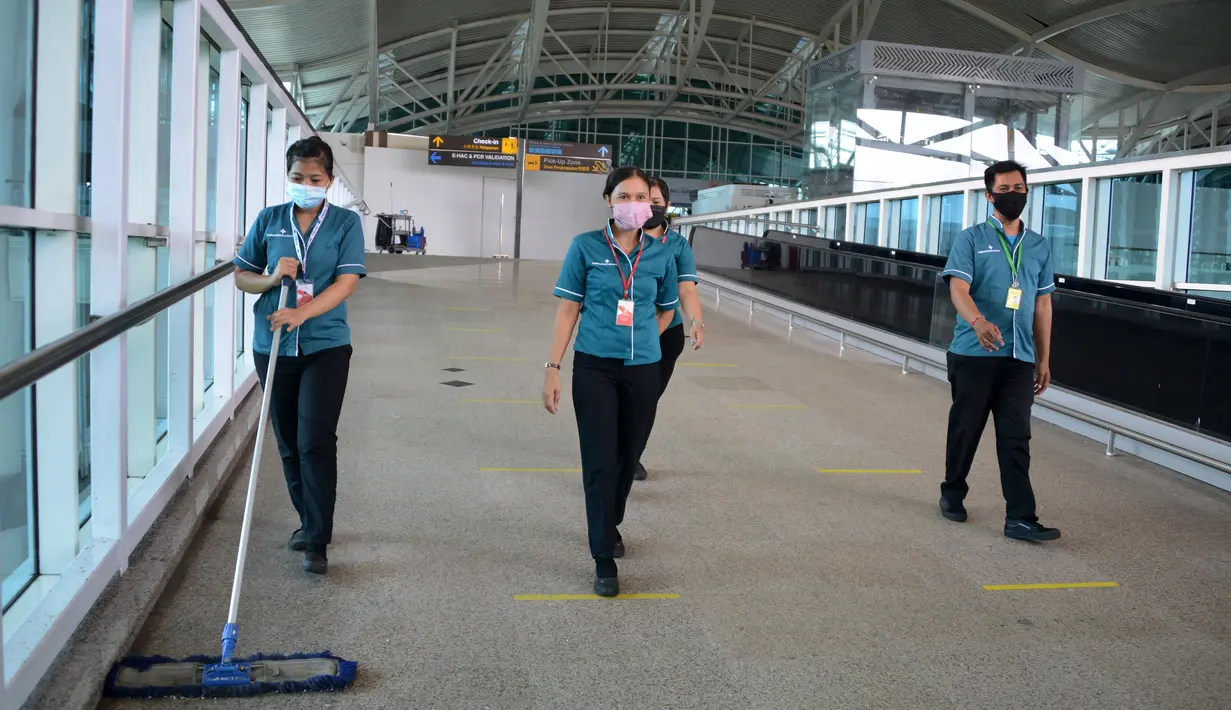 Pekerja membersihkan area keberangkatan internasional di bandara Ngurah Rai di Tuban dekat Denpasar di pulau resor Bali (5/10/2021).  Bandara Ngurah Rai akan kembali dibuka pada 14 Oktober untuk beberapa pelancong internasional. (AFP/Sony Tumbelaka)