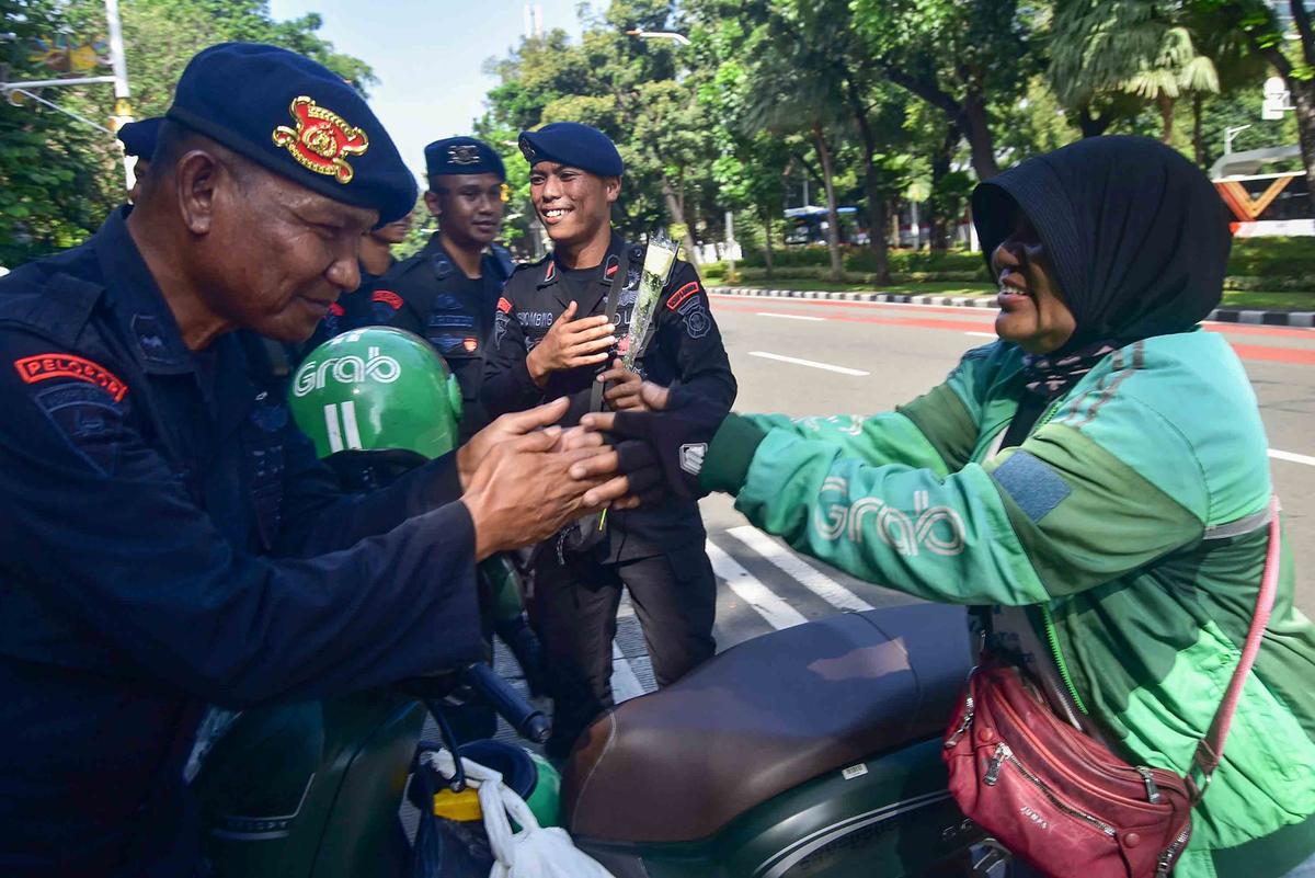 FOTO: Aksi Damai Ojol Tebar Mawar untuk Perdamaian