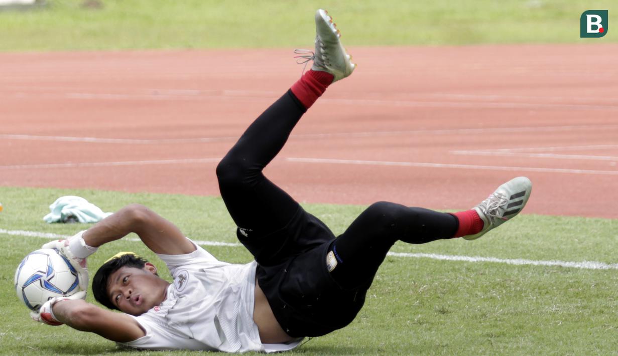 Kiper Timnas Indonesia, Muhammad Riyandi, menangkap bola saat sesi latihan di Stadion Madya, Jakarta, Selasa, (18/2/2020). Untuk meningkatkan performa kiper, Shin Tae-yong menambah porsi waktu latihan. (Bola.com/M Iqbal Ichsan)