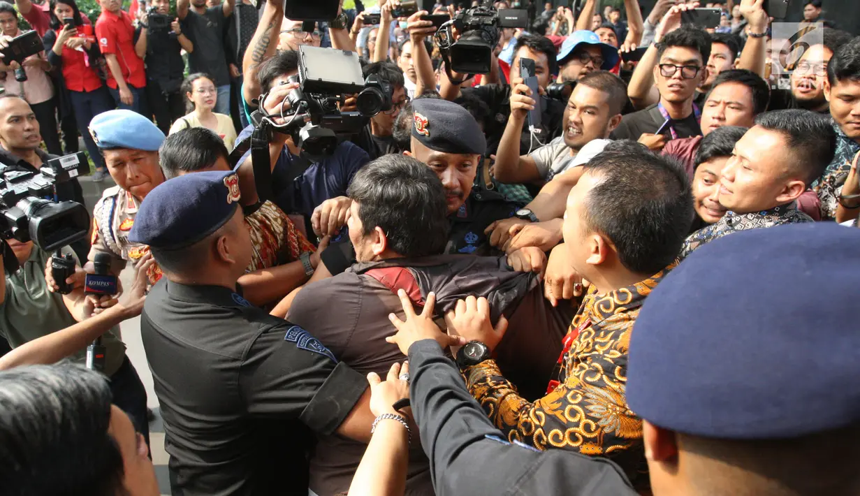 Polisi dan petugas pengamanan mencoba menghalau massa yang mencoba masuk ke gedung KPK, Jakarta, Jumat (13/9/2019). Sempat terjadi baku hantam dalam demo itu saat massa aksi pendukung revisi Undang-Undang KPK mencoba merangsek untuk mencopot kain hitam yang menutupi logo KPK. (Liputan6.com/HO/Andri)