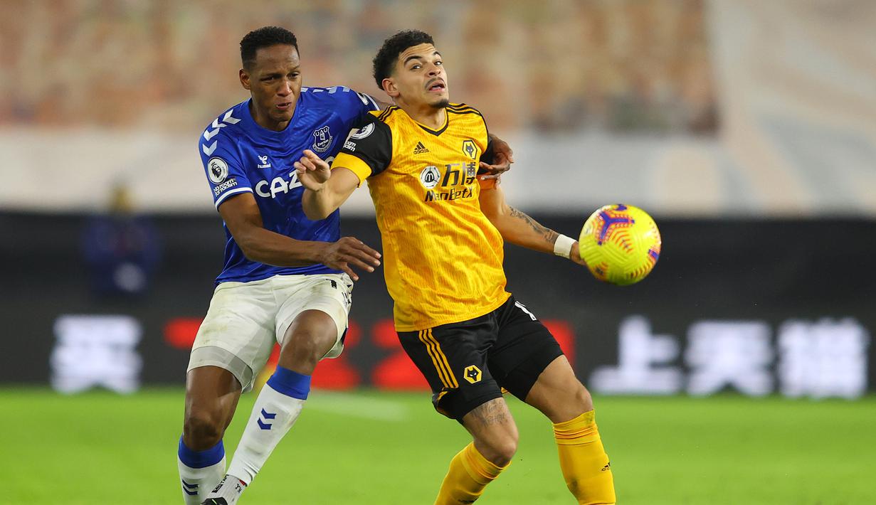 Bek Everton, Yerry Mina (kiri) berebut bola dengan gelandang Wolverhampton Wanderers, Morgan Gibbs-White dalam laga lanjutan Liga Inggris 2020/21 di Molineux Stadium, Selasa (12/1/2021). Everton menang 2-1 atas Wolverhampton Wanderers. (AFP/Richard Heathcote/Pool)