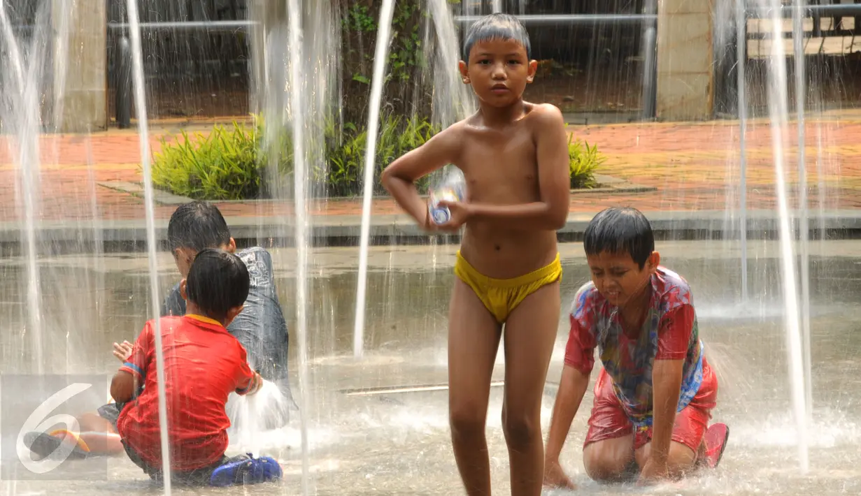 Sejumlah anak-anak bermain air di Taman Kodok kawasan Menteng, Jakarta, Minggu (17/1/2016). Taman Kodok kerap dijadikan tempat bermain oleh sejumlah anak pada setiap hari libur. (Liputan6.com/Faisal R Syam)