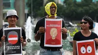 Peserta aksi memegang poster saat aksi peringati hari Hak Asasi Manusia (HAM) 2015 di Bundaran HI, Jakarta, Kamis (10/12/2015). Aksi untuk memperingati Hari HAM Internasional yang jatuh setiap tanggal 10 Desember. (Liputan6.com/Faizal Fanani)