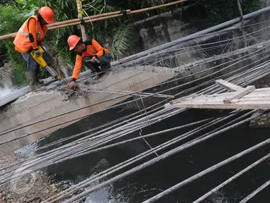 Petugas Suku Dinas Bina Marga Jakarta Barat memperbaiki Jembatan Kali Inspeksi Grogol, Jakarta, (30/5/2016). Amblesnya jembatan yang terletak depan kompleks Hankam, Palmerah tersebut penyebabnya diduga terjadi pergeseran tanah (Liputan6.com/Helmi Afandi)