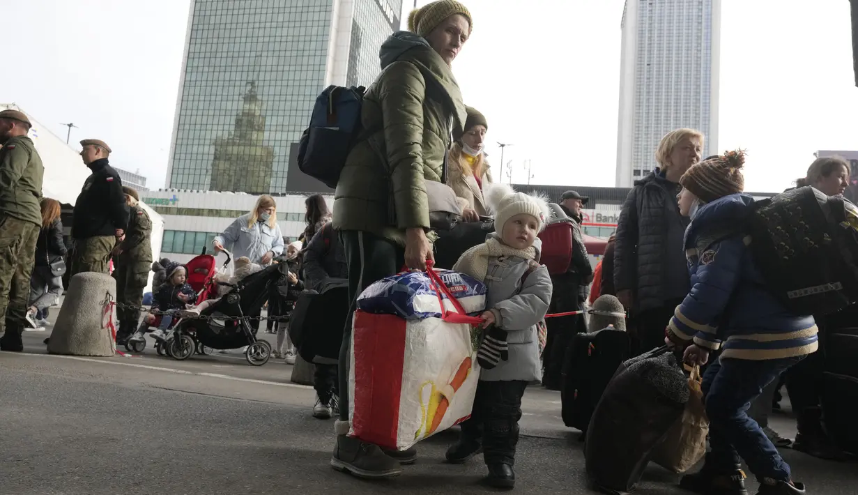 Pengungsi Ukraina menunggu transportasi di stasiun kereta pusat di Warsawa, Polandia, Minggu (27/3/2022). Lebih dari 3,7 juta orang telah melarikan diri dari perang Rusia vs Ukraina sejauh ini, eksodus terbesar di Eropa sejak Perang Dunia II. (AP Photo/Czarek Sokolowski)