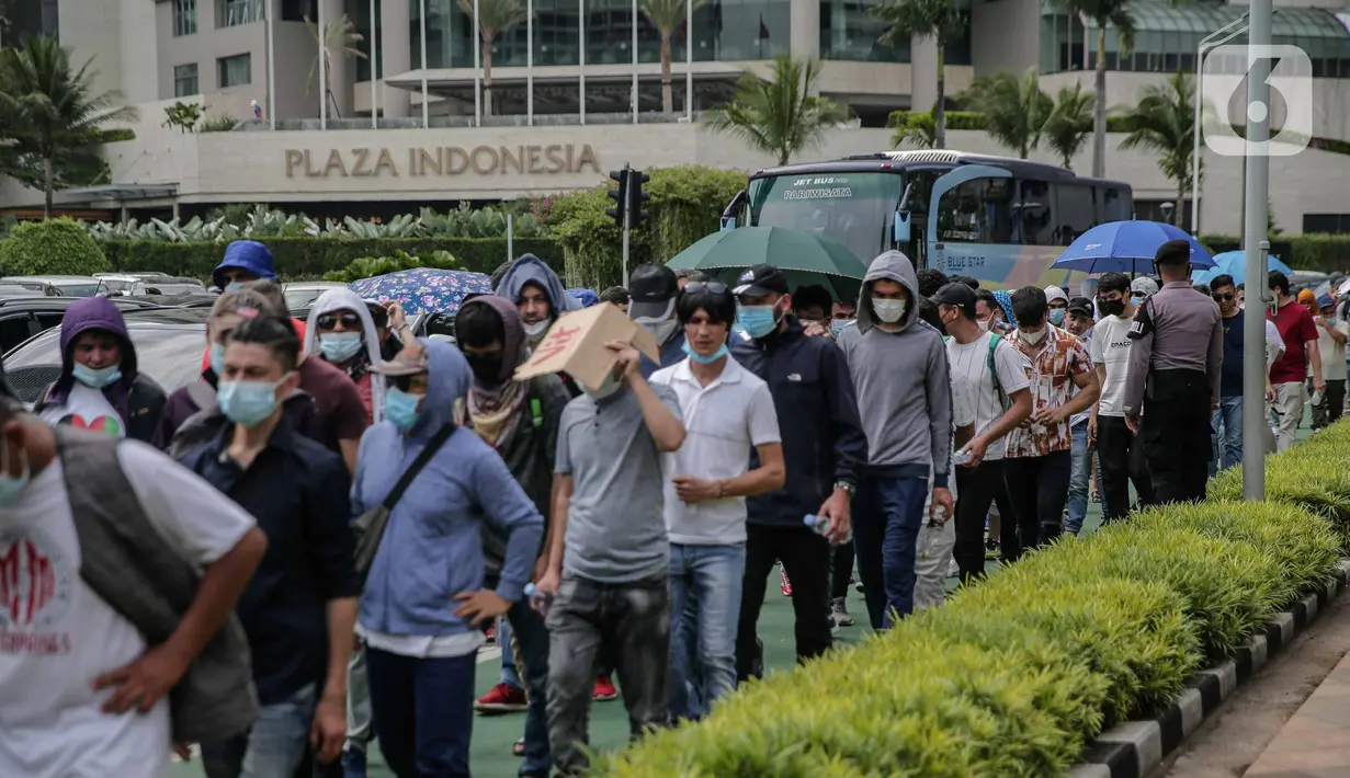 Ratusan imigran Afghanistan jalan kaki menuju Kedubes Kanada di Jakarta, Senin (13/12/2021). Dengan membawa spanduk dan poster, mereka menuntut UNHCR dan IOM segera memproses penempatan mereka ke negara tujuan seperti Kanada, Australia, Selandia Baru maupun AS. (Liputan6.com/Faizal Fanani)