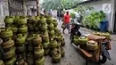Pekerja menata tabung gas elpiji 3 kg ke atas sepeda motor untuk didistribusikan di kawasan Jakarta, Rabu (4/1/2023). Pembelian menggunakan KTP ini diterapkan agar pembelian LPG 3 kg dapat dinikmati oleh masyarakat yang berhak atau tepat sasaran. (Liputan6.com/Angga Yuniar)