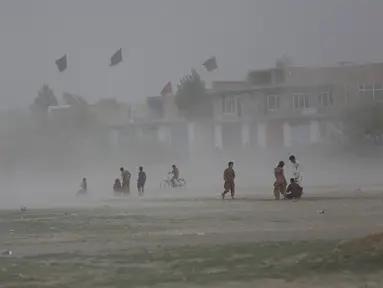 Anak laki-laki Afghanistan bermain saat badai pasir di pinggiran Kabul, Afghanistan (25/8/2020). Sebuah badai pasir hebat melanda Kabul. Badai menyebabkan jarak pandang jadi berkurang. (AP Photo / Rahmat Gul)