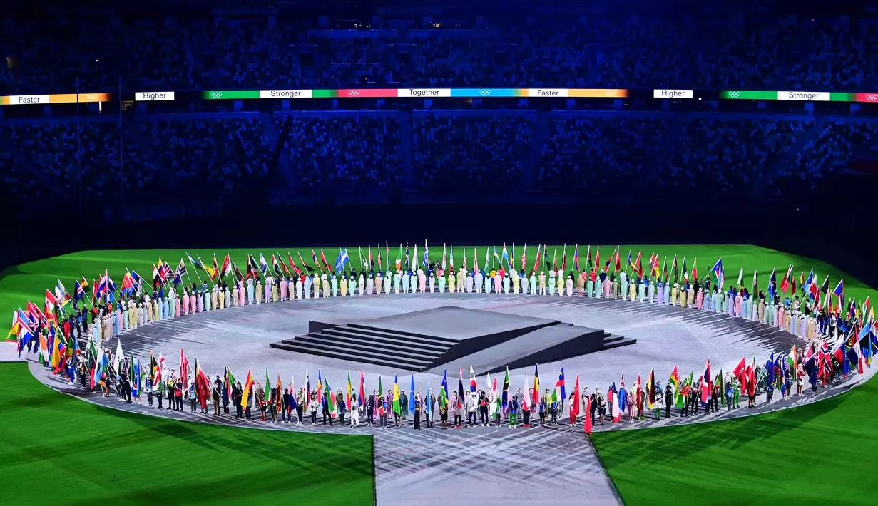 Atlet pembawa bendera tiba dengan membawa bendera nasional mereka saat upacara penutupan Olimpiade Tokyo 2020, di Stadion Olimpiade, Tokyo, pada 8 Agustus 2021.
(AFP/Pedro Pardo)