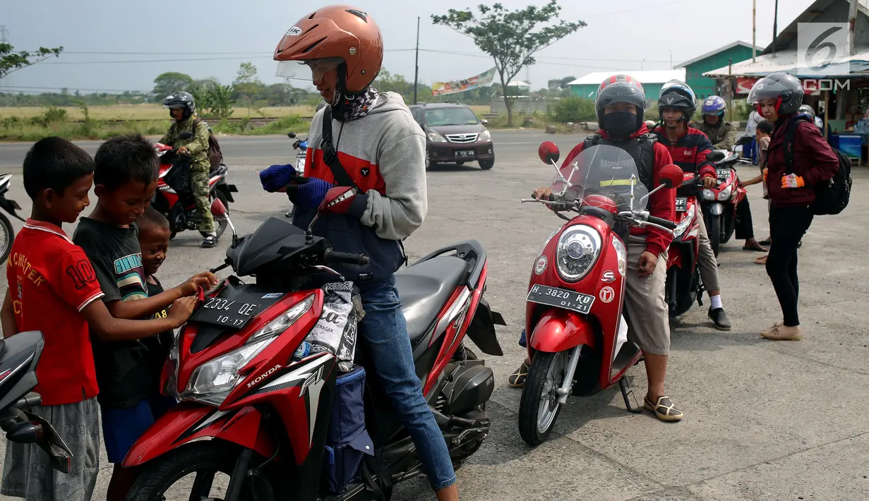 Anak - anak di SPBU Tanjung Pantura - Brebes membersihakan motor pemudik dari Jakarta menuju kampung halamannya, Kamis (22/6). Memanfaatkan moment mudik ini anak - anak pantura mengais rejeki untuk lebaran 1438 H. (Liputan6.com/Johan Tallo)