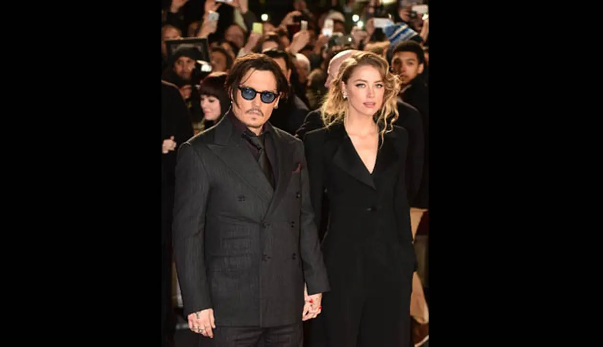 Johnny Depp dan Amber Heard hadir bersamaan dan saling bergandengan mesra di karpet merah premier film 'Mortdecai' di London, Senin (19/1/2015). (AFP PHOTO/Leon NEAL)