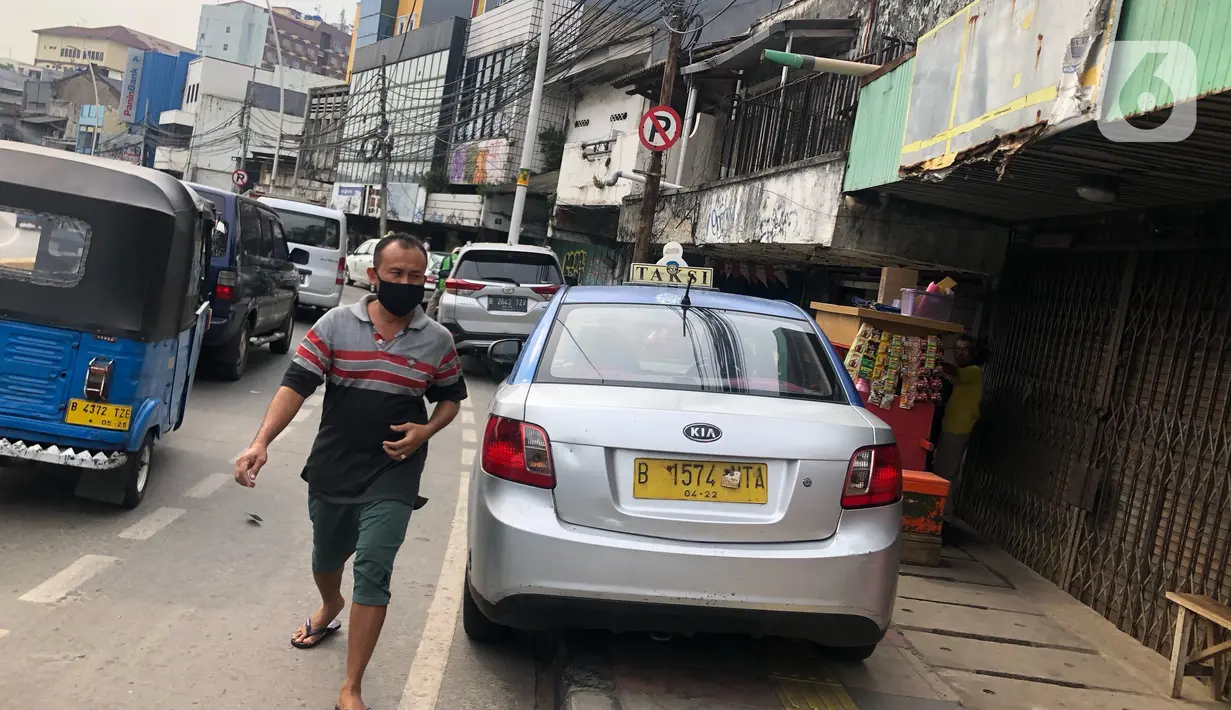 Sebuah taksi terparkir di sekitar trotoar kawasan Jatinegara, Jakarta, Selasa (14/7/2020). Tidak adanya sanksi tegas membuat trotoar yang telah diperlebar tersebut justru dimanfaatkan sebagai lahan parkir liar yang mengganggu ketertiban umum. (Liputan6.com/Immanuel Antonius)