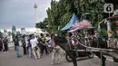 Petugas Satpol PP dari Wali Kota Jakarta Pusat saat mensosialisasikan terkait rencana larangan delman di kawasan Monas, Jakarta Pusat, Minggu (8/1/2023). Pemkot Jakarta Pusat berencana melarang delman beroperasi di kawasan Monas karena kotoran kuda yang berceceran di jalan dinilai menimbulkan bau tak sedap. Plt Wakil Wali Kota Administrasi Jakarta Pusat Iqbal mengatakan pihaknya bakal membentuk gugus tugas merealisasikan kebijakan tersebut. (merdeka.com/Iqbal S. Nugroho)