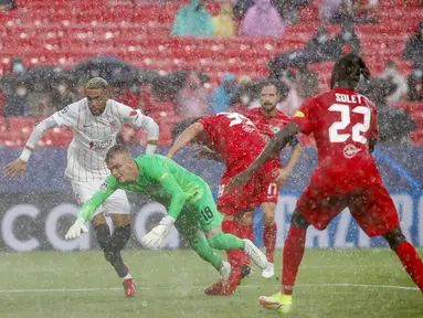 Penjaga gawang Salzburg Philipp Koehn (kedua kiri) mencoba menyelamatkan bola saat melawan Sevilla pada pertandingan Grup G Liga Champions di Stadion Ramon Sanches Pizjuan, Seville, Spanyol, Selasa (14/9/2021). Pertandingan berakhir dengan skor 1-1. (AP Photo/Angel Fernandez)