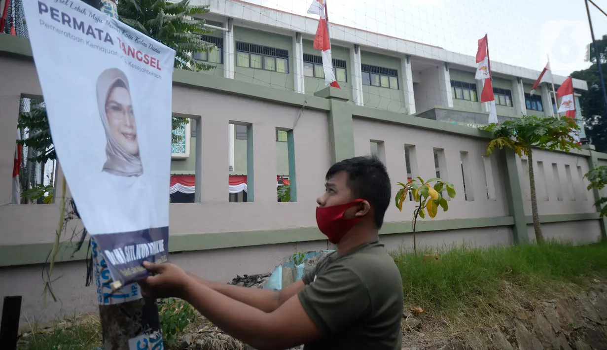 Petugas Satpol PP menertibkan Alat Peraga Kampanye (APK) bakal calon Wali Kota dan Wakil Wali Kota Tangerang Selatan di sepanjang jalan raya di Kota Tangerang Selatan, Kamis (27/8/2020). Semua poster dan baliho diturunkan karena tidak memiliki izin dan masa izin telah habis. (merdeka.com/Dwi Narwoko