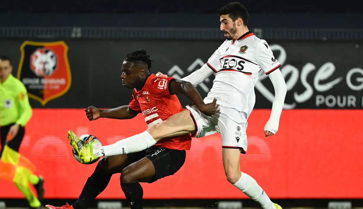 Striker Rennes, Jeremy Doku (kiri) berebut bola dengan gelandang Nice, Pierre Lees-Melou dalam laga lanjutan Liga Prancis 2020/21 pekan ke-27 di Roazhon Park Stadium, Rennes, Jumat, (26/2/2021). Rennes kalah 1-2 dari Nice. (AFP/Damien Meyer)