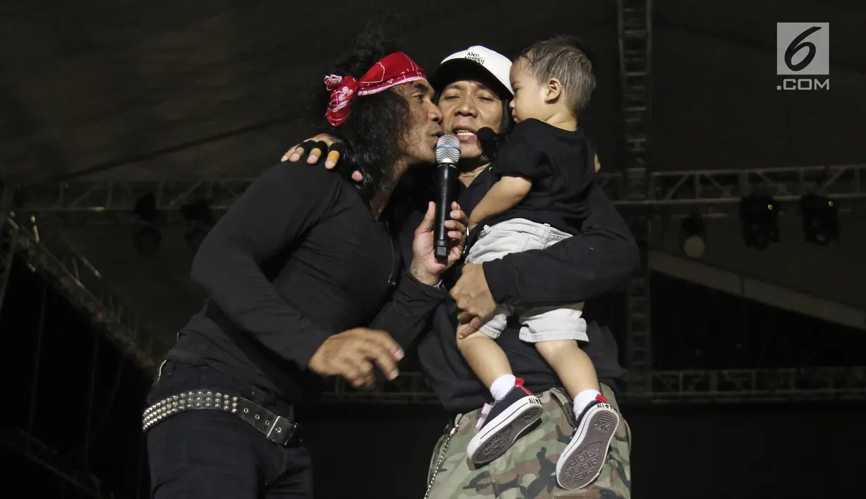 Personel Slank, Kaka dan BimBim mengajak keluarga besar Slank naik ke atas panggung konser perayaan HUT ke-34 di JIExpo Kemayoran, Jakarta, Selasa (26/12). Band beraliran rock dan blues itu berdiri sejak 26 Desember 1983. (Liputan6.com/Herman Zakharia)