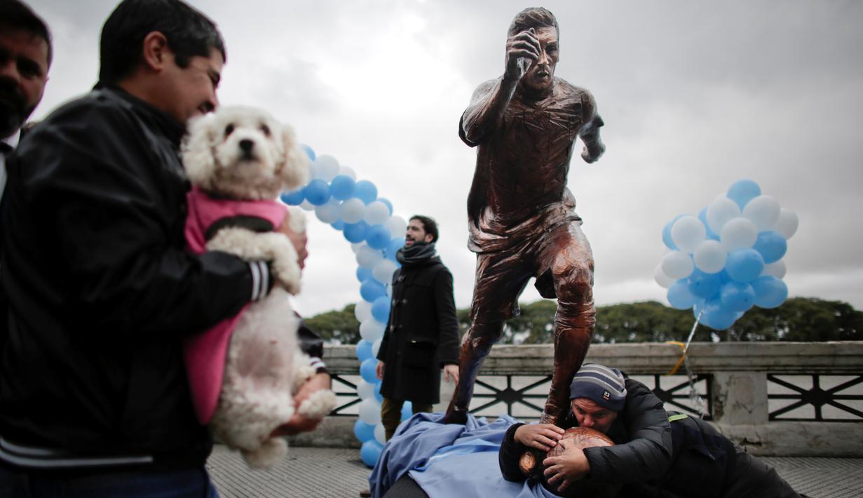 Seorang penggemar mencium patung Lionel Messi seusai Argentina gagal menjadi juara Copa America Centenario 2016 di Buenos Aires, Argentina, (28/6/2016). (AP Photo/Victor R. Caivano)
