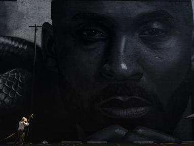 Seorang fotografer mengambil gambar mural yang menggambarkan Kobe Bryant di Los Angeles, Rabu, 24 Agustus 2022. Mural, yang dilukis oleh seniman jalanan Portugis Odeith dan seniman dan ilustrator kontemporer Amerika Nikkolas Smith tersebut untuk merayakan Kobe Bryant Day. (AP Photo/Jae C. Hong)