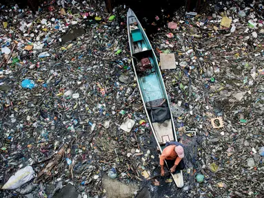 Seorang pekerja mengumpulkan sampah dari Sungai Marilao di Bulacan, sebelah utara Manila, 18 Maret 2017. Sungai di Filipina ini disebut sebagai salah satu 30 tempat terkotor di dunia. (Noel CELIS/AFP)