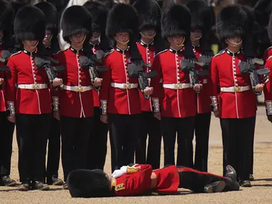 Seorang petugas Pengawal Welsh pingsan dalam cuaca panas selama parade militer yang dikenal sebagai Colonel's Review, latihan terakhir persiapan parade Trooping the Color tahunan, di Horse Guards Parade di London, Sabtu, 10 Juni 2023. (AP Photo/Alberto Pezzali)