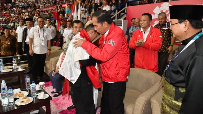 Presiden Joko Widodo atau Jokowi menyalami atlet pencak silat peraih emas Asian Games 2018 Hanifan Yudani disaksikan Ketua Umum Pengurus Besar Ikatan Pencak Silat Indonesia (IPSI) Prabowo Subianto, Jakarta, Rabu (29/8). (Liputan6.com/HO/Biro Pers Setpres)