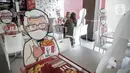 Pengunjung menikmati makanan di meja yang diberi pembatas banner bergambar karakter di KFC Salemba, Jakarta, Selasa (23/6/2020). Banner bergambar tersebut berguna untuk pembatas bagi pengunjung yang makan di tempat saat fase kenormalan baru. (Liputan6.com/Faizal Fanani)