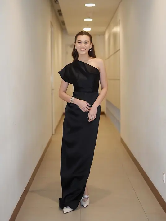 Gaya elegan Aaliyah Massaid pakai dress hitam dengan bahu asimetris. Simpel, namun tetap cantik, Aaliyah Massaid terlihat menambahkan beberapa aksesori yang tak berkesan berlebihan, seperti anting, gelang, dan cincin. [Foto: Instagram/Aaliyah.massaid]