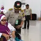 Dua petugas membantu jemaah haji lansia yang menggunakan kursi roda pada pemberangkatan di Asrama Embarkasi Haji Antara Gorontalo (Foto : Haris)