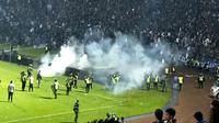 Aparat keamanan&nbsp;melepas tembakan gas air mata untuk menghalau massa dalam kerusuhan di Stadion Kanjuruhan Malang pada Sabtu, 1 Oktober 2022 (Liputan6.com/Zainul Arifin)
