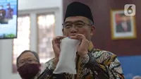 Menko PMK Muhadjir Effendy memperagakan alat GeNose C19 buatan Universitas Gadjah Mada (UGM) di Kementerian PMK, Jakarta, Kamis (7/1/2021). Alat itu diserahkan oleh Menteri Riset dan Teknologi Bambang Brodjonegoro, Kamis (7/1/2021). (merdeka.com/Imam Buhori)